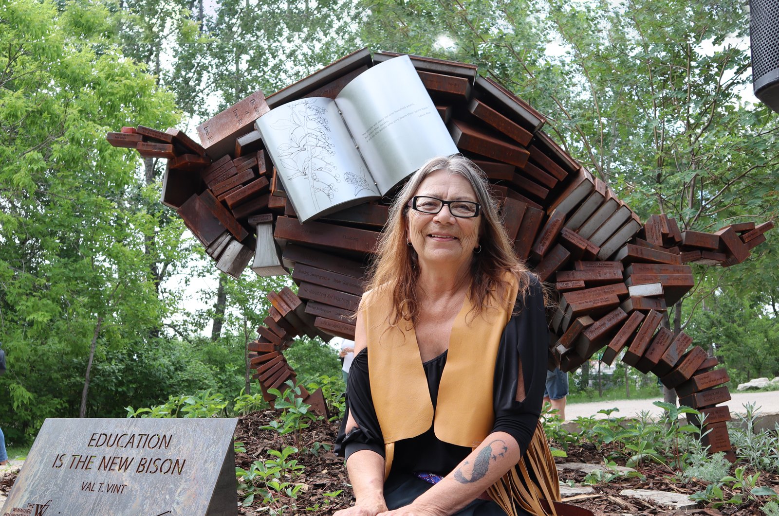 Val Vint sitting in front of Education Is the New Bison art piece