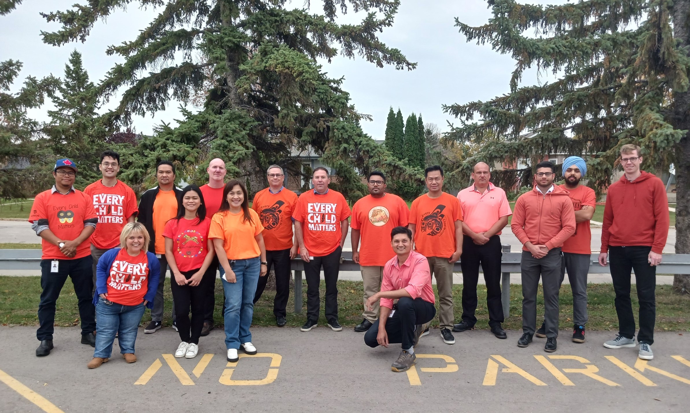 The SolutionAir team, wearing orange shirts, standing outside