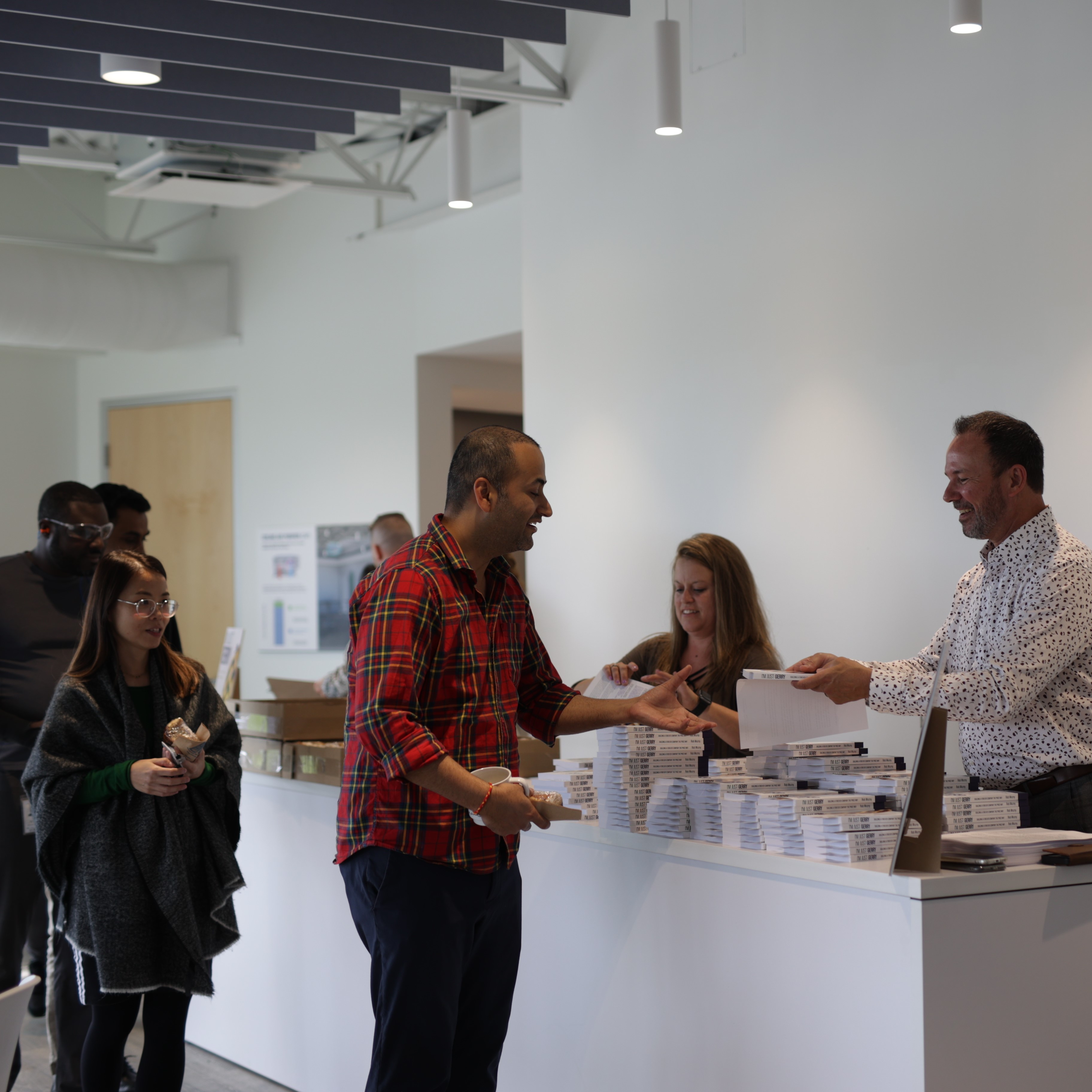 Employees receiving copies of the book in Winnipeg