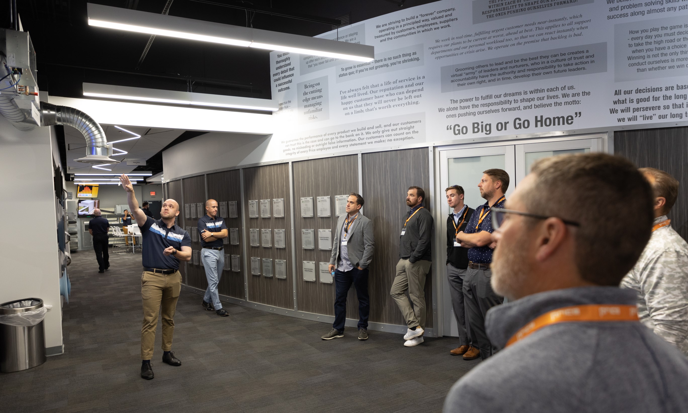 Ryan Johnson explains the Systems Wall to visitors