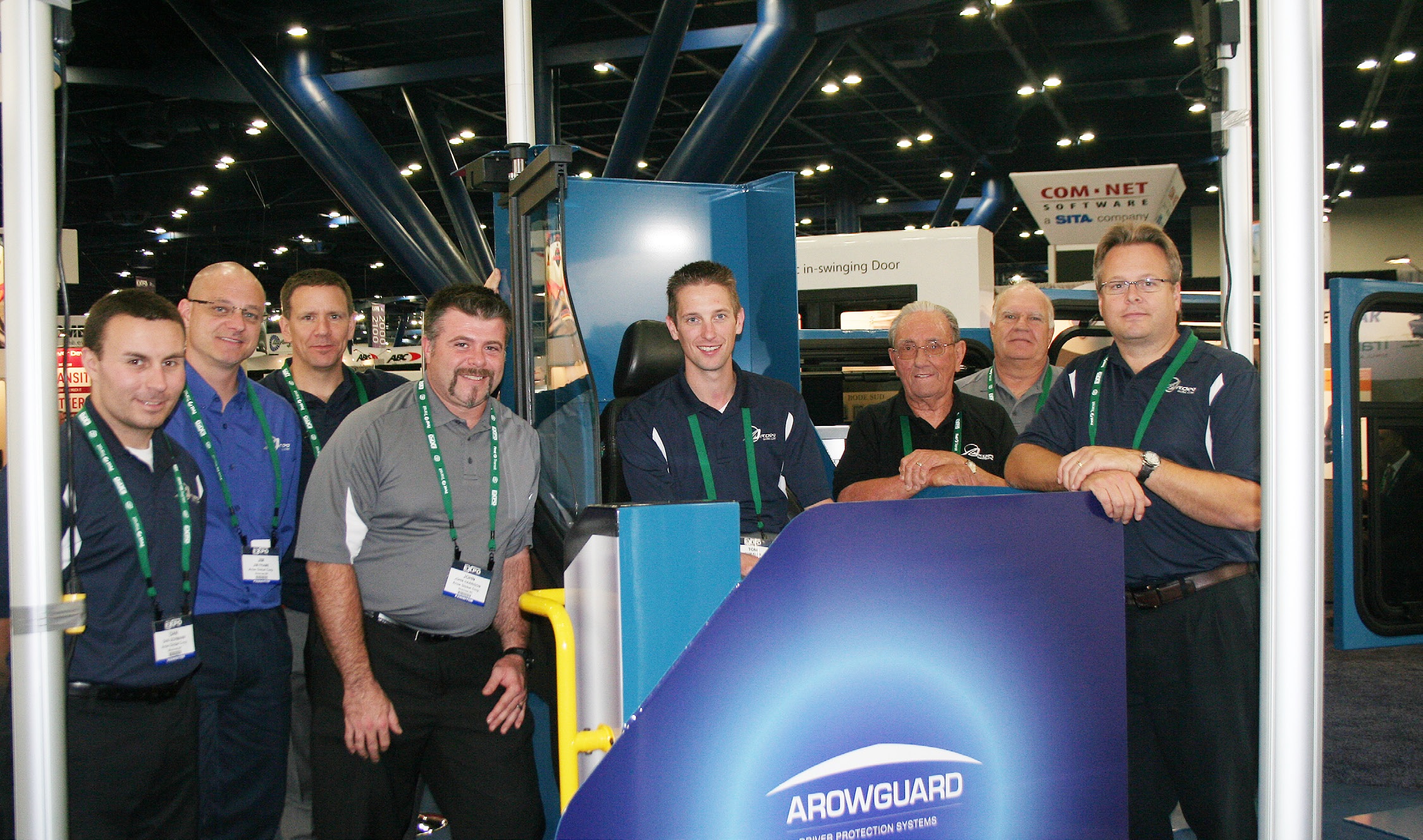 A group shot of 8 men attending a trade show