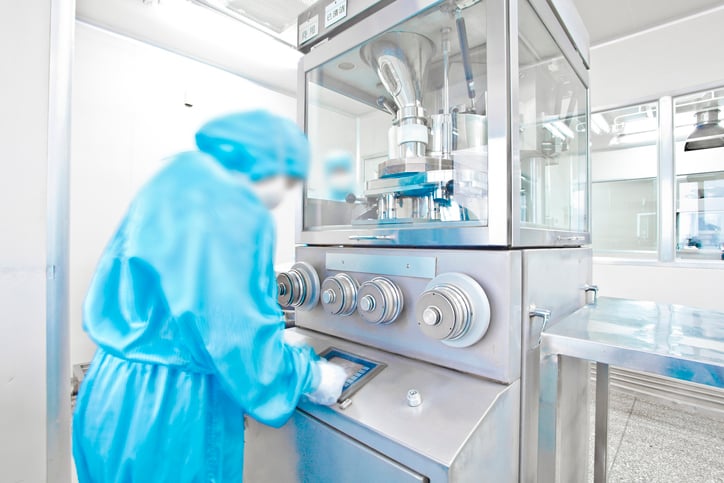 An employee in protective gear working in a cleanroom