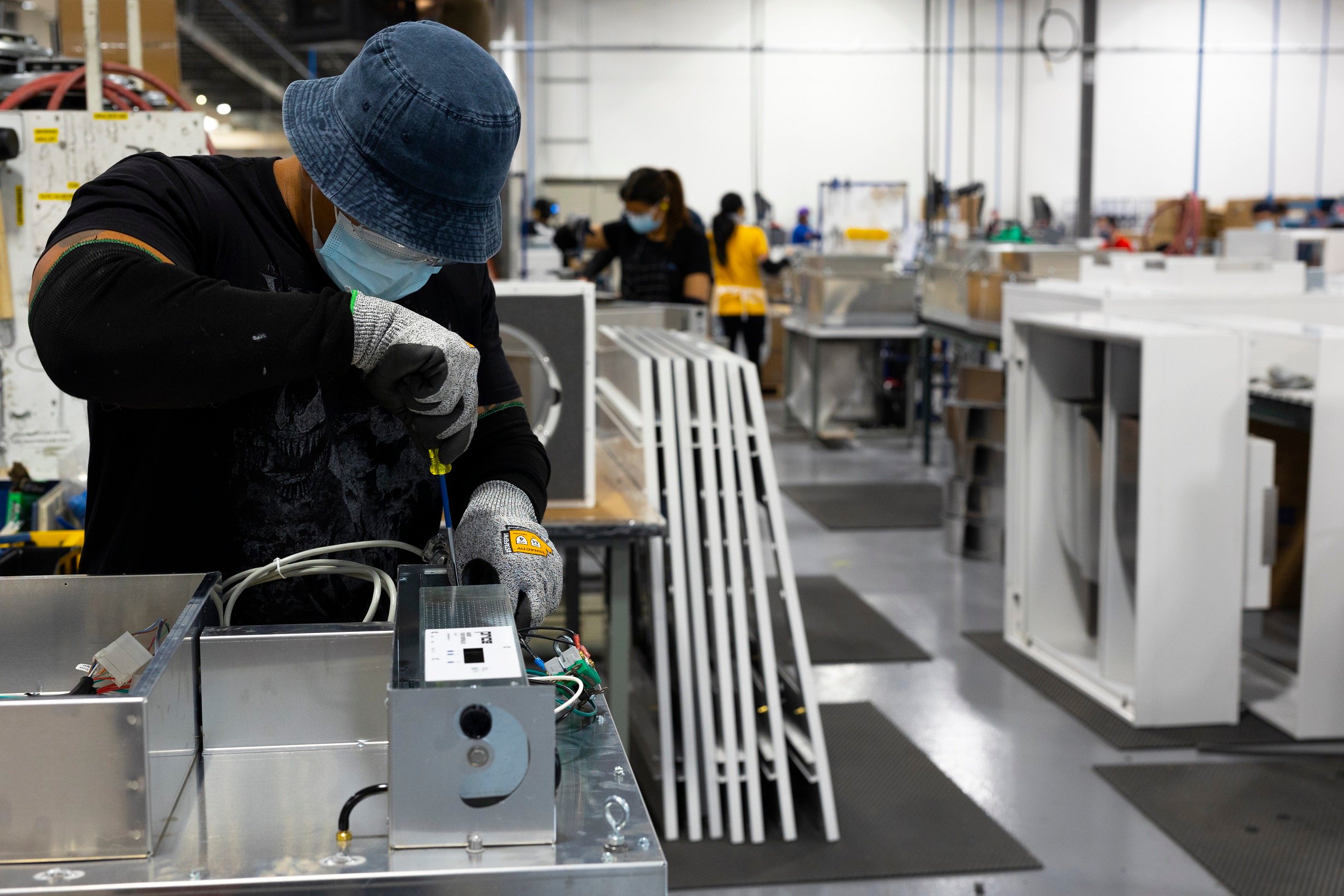 Team member using a screw driver on a fan filter unit