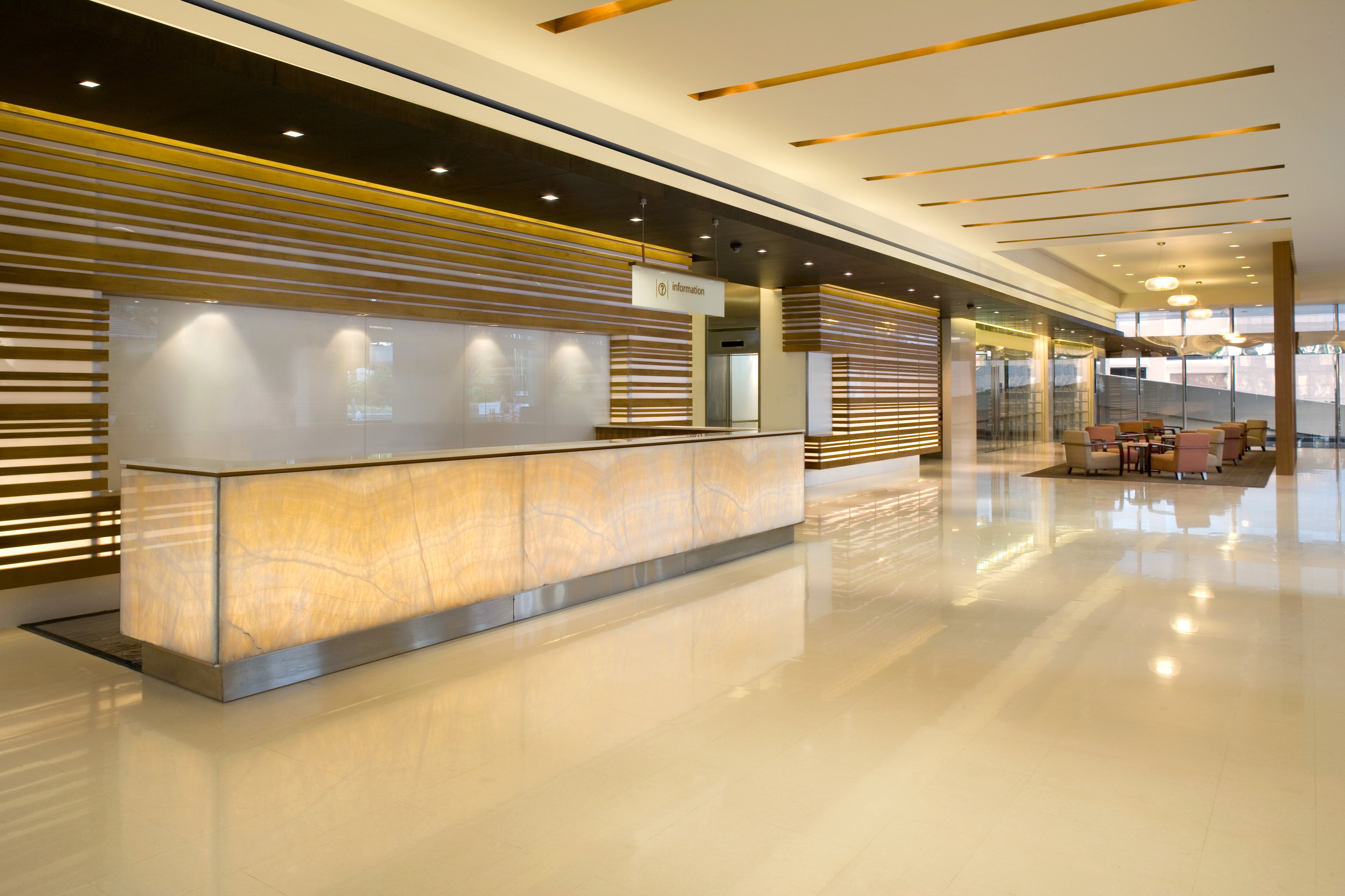Hotel lobby with linear slot diffuser installed in bulkhead above reception desk