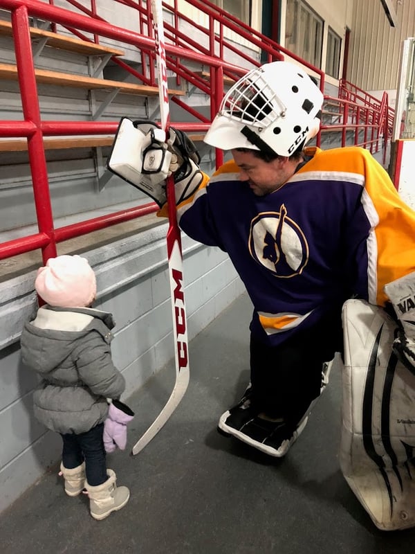 Justen Vogt in Goalie gear talking to his young daughter