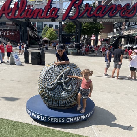 Michael's two children standing with the Atlanta Braves Word Series Champions statue