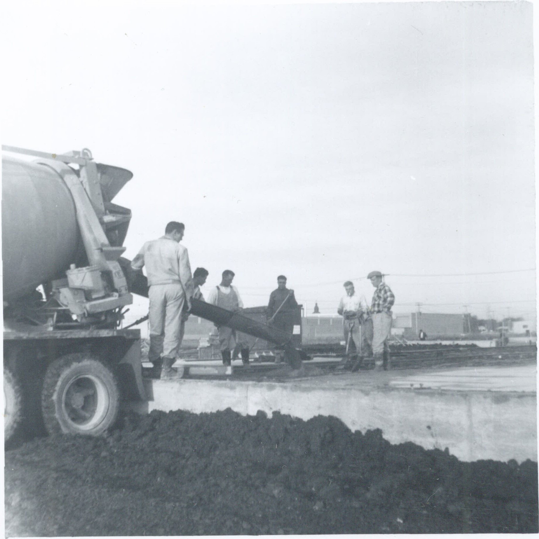 Construction site with workers standing near a concrete mixer