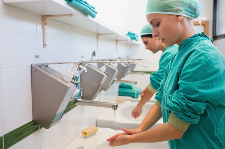 Two surgeons washing their hands in a hospital sink