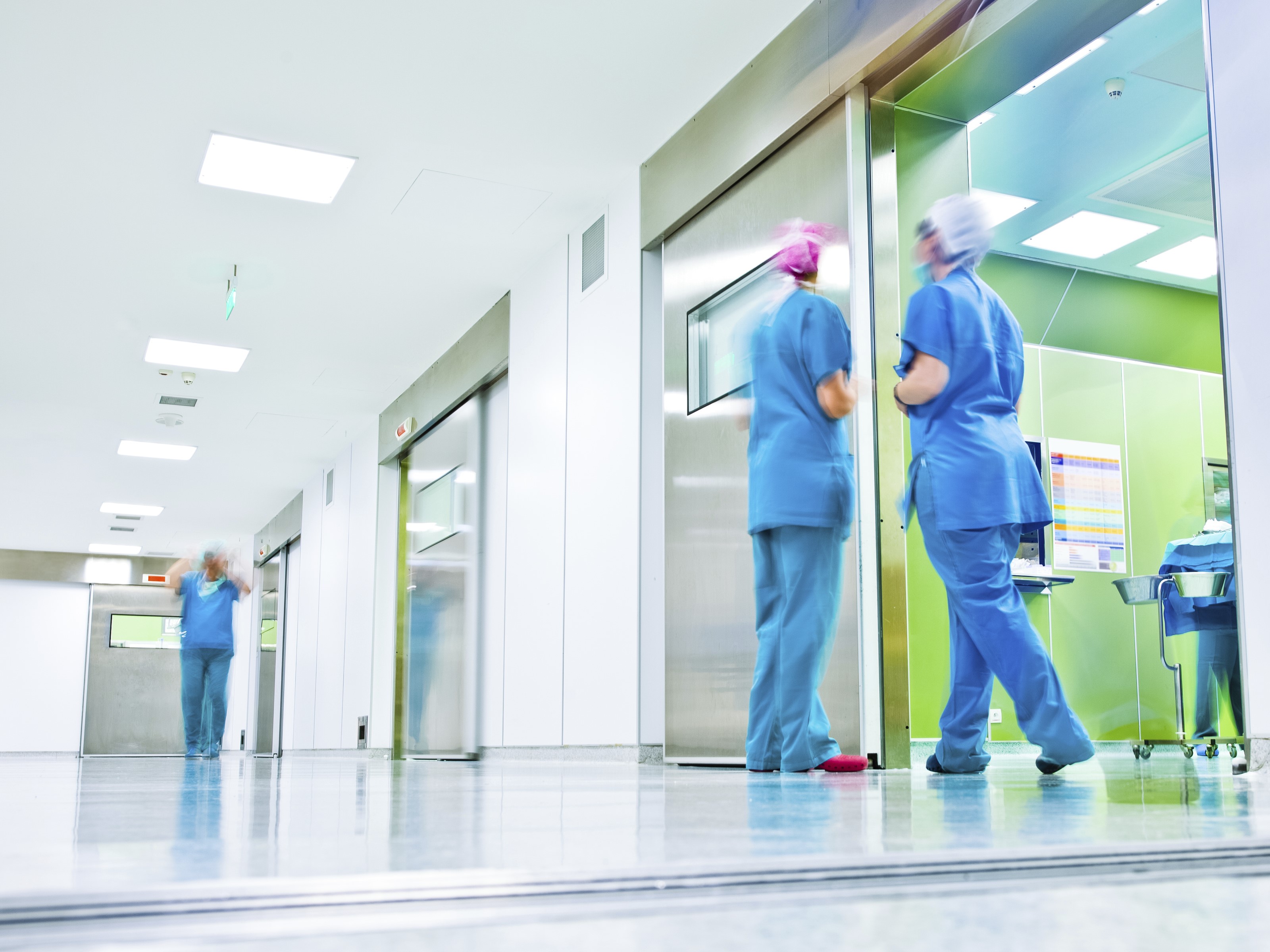 A hospital corridor with employees in scrubs